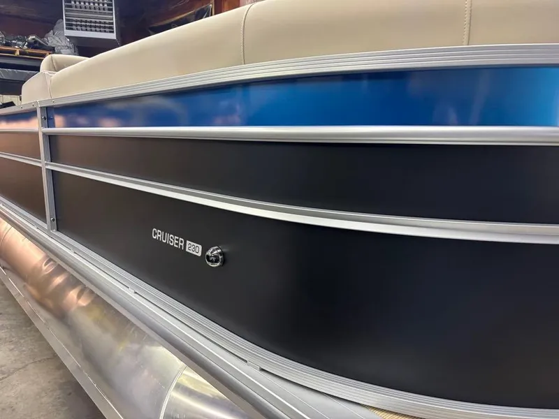 Slide: The Image of 2025 Harris CRUISER 230 SL pontoon boat with sleek black and blue exterior design. - 14