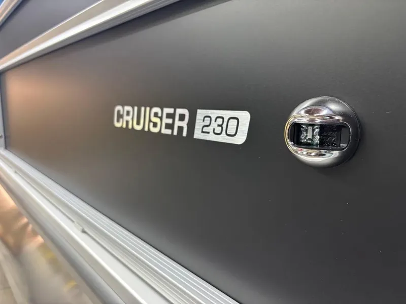 Slide: The Image of 2025 Harris CRUISER 230 SL boat emblem on sleek metallic surface. - 2