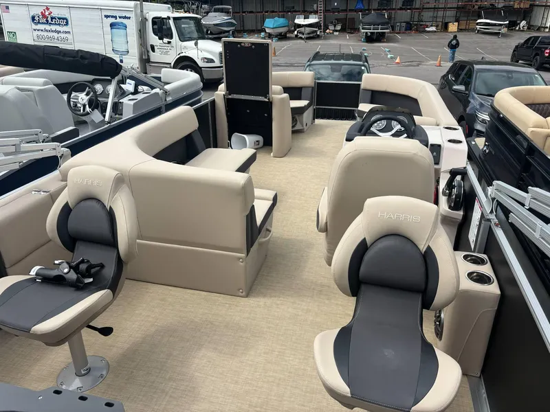 Slide: The Image of 2025 Harris Cruiser 230 pontoon boat interior with beige seating and steering wheel. - 4