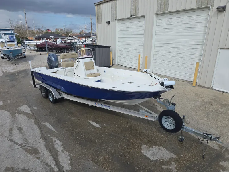 Slide: The Image of 2019 NauticStar 244 XTS boat on trailer, parked outside a warehouse. - 3