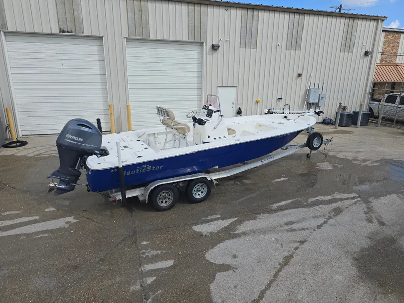 Slide: The Image of 2019 NauticStar 244 XTS boat on trailer, parked outside a warehouse. - 4