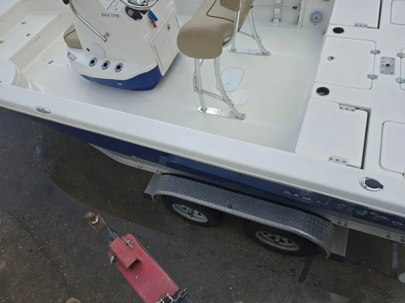 Slide: The Image of 2019 NauticStar 244 XTS boat on trailer, featuring seating and storage compartments. - 7