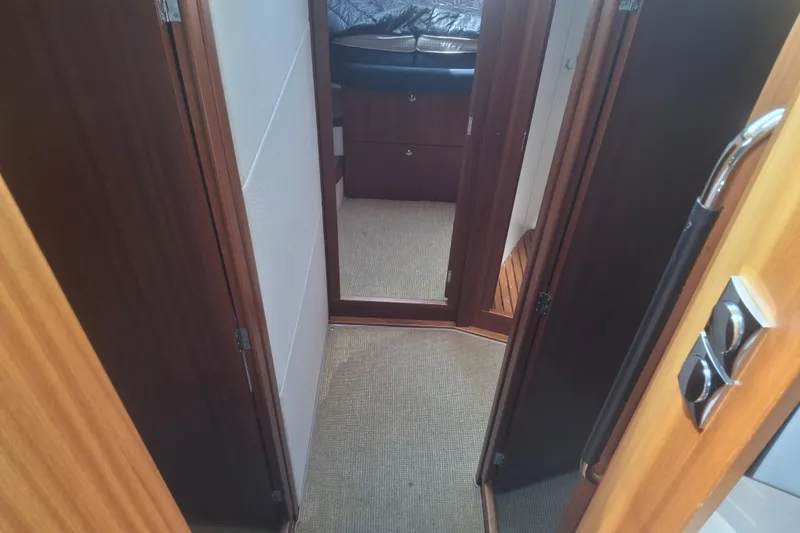 Slide: The Image of Interior hallway of 2017 Nimbus 405 Flybridge yacht with wooden doors and carpeted floor. - 17