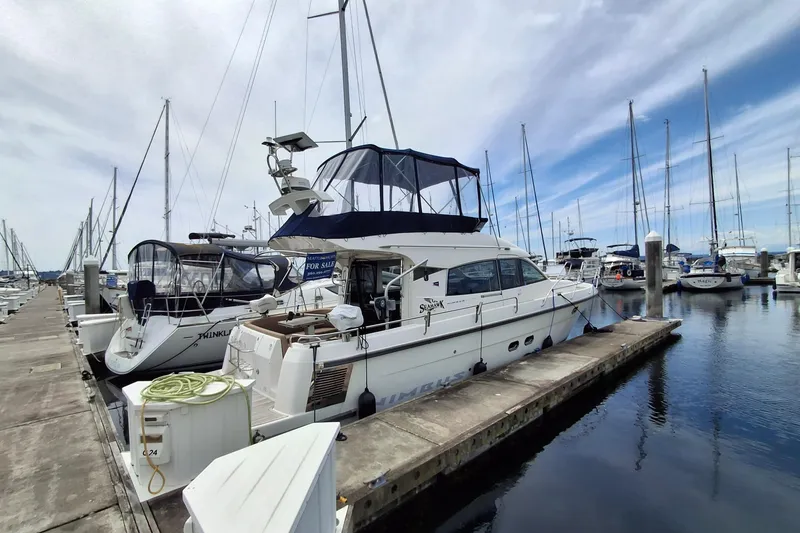 Slide: The Image of Nimbus 405 Flybridge 2017 yacht docked at marina with clear sky and sailboats. - 2