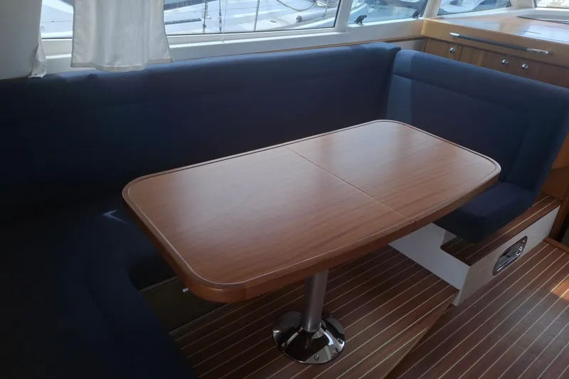 Slide: The Image of Luxurious interior of 2017 Nimbus 405 Flybridge with elegant wooden table and blue seating. - 20