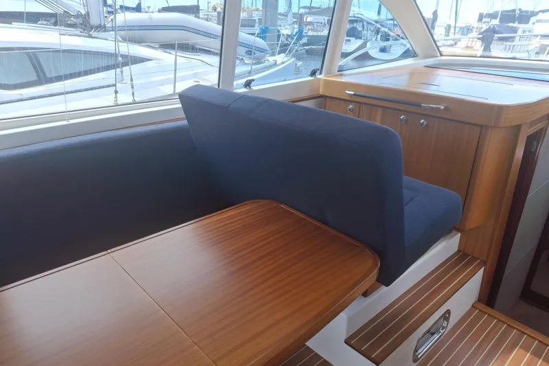 Slide: The Image of Interior of 2017 Nimbus 405 Flybridge yacht with wooden table and blue seating. - 21