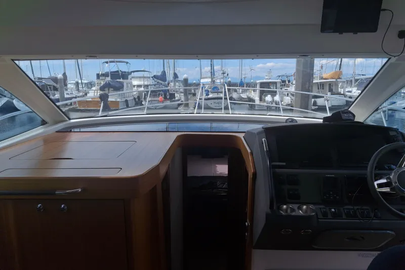 Slide: The Image of Interior view of 2017 Nimbus 405 Flybridge yacht at marina, showcasing helm and dashboard. - 23