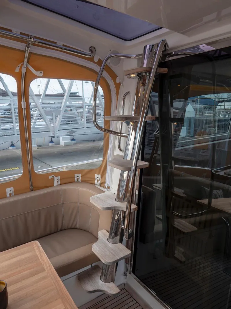 Slide: The Image of Interior of 2017 Nimbus 405 Flybridge yacht with sleek metal staircase and cozy seating area. - 43