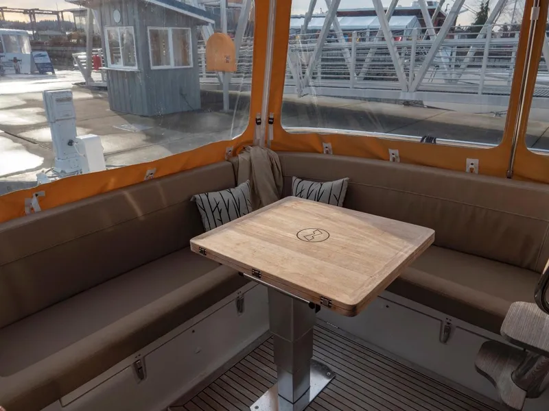Slide: The Image of Cozy seating area on 2017 Nimbus 405 Flybridge with wooden table and cushions. - 44