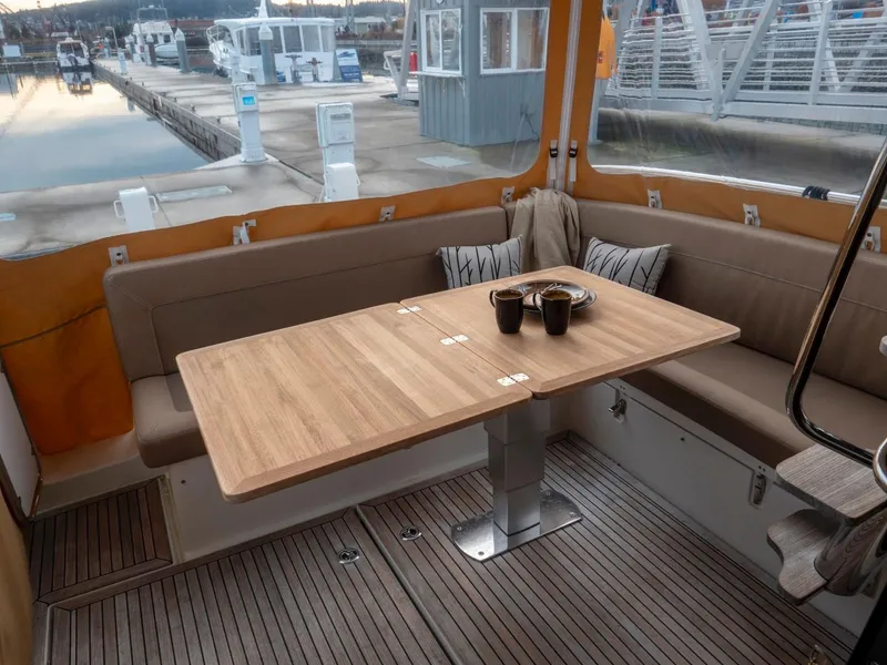 Slide: The Image of Cozy seating area on 2017 Nimbus 405 Flybridge yacht with wooden table and cushions. - 45