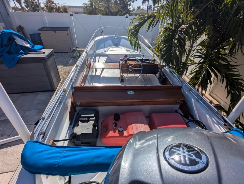 Slide: The Image of 1987 Boston Whaler 150 Super Sport boat, docked, with visible steering wheel and engine. - 10