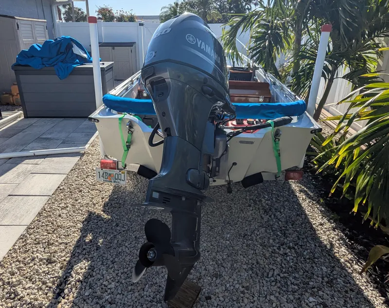 Slide: The Image of 1987 Boston Whaler 150 Super Sport with Yamaha outboard motor, parked on gravel driveway. - 12