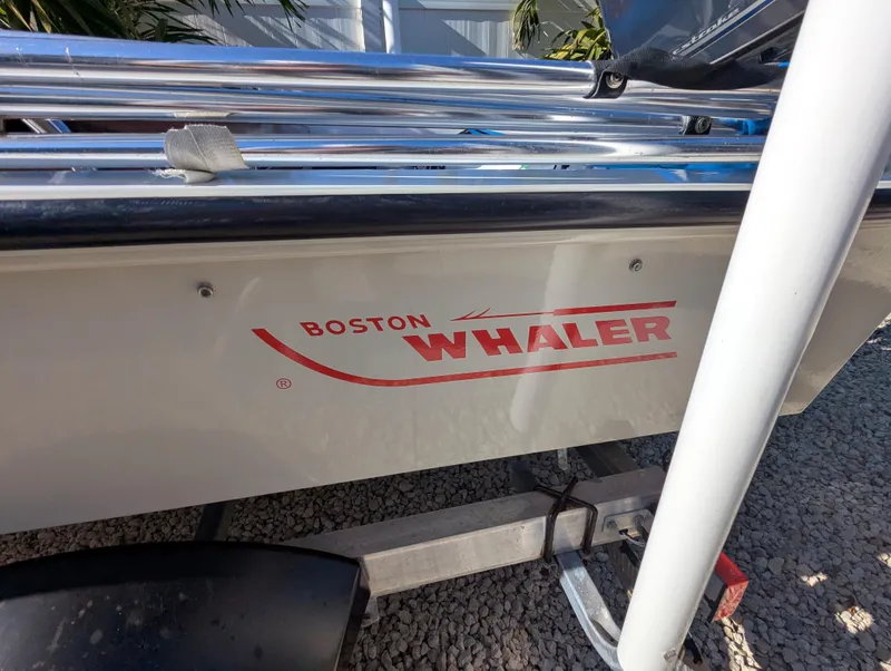 Slide: The Image of 1987 Boston Whaler 150 Super Sport boat on trailer, side view with logo. - 2