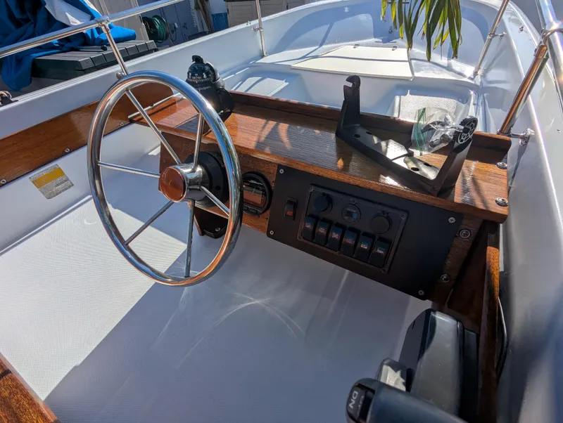 Slide: The Image of 1987 Boston Whaler 150 Super Sport boat dashboard with steering wheel and control panel. - 5