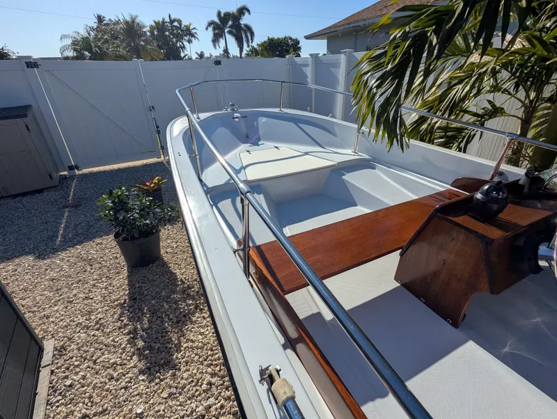 Slide: The Image of 1987 Boston Whaler 150 Super Sport boat in a sunny backyard setting. - 6