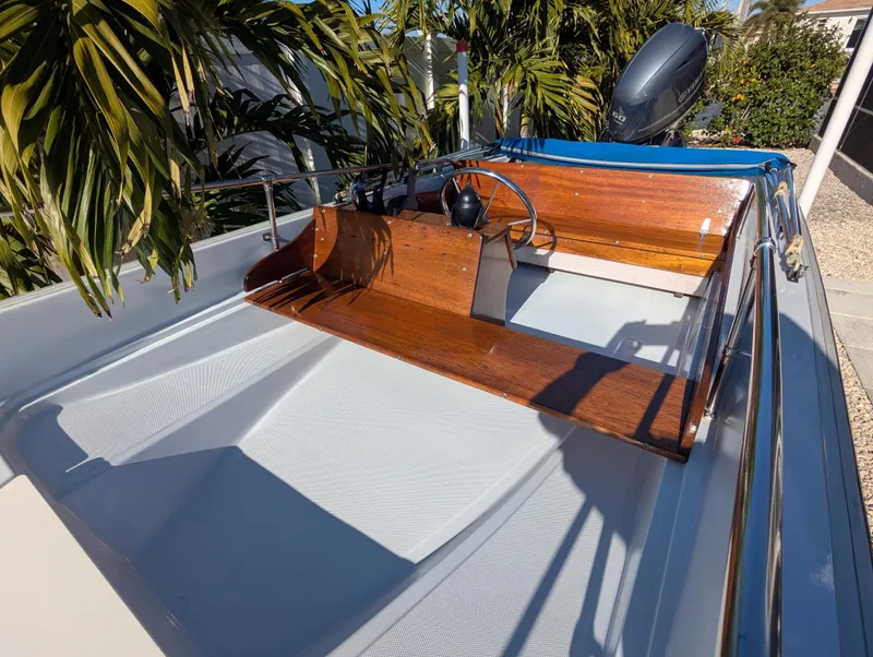 Slide: The Image of 1987 Boston Whaler 150 Super Sport boat with wooden console, surrounded by tropical plants. - 7