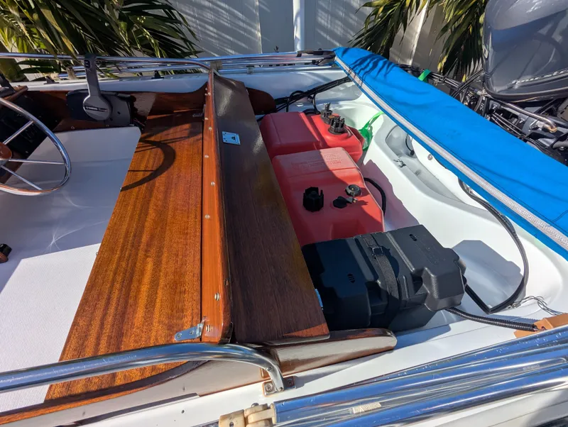 Slide: The Image of 1987 Boston Whaler 150 Super Sport interior with wooden accents and fuel tank. - 8