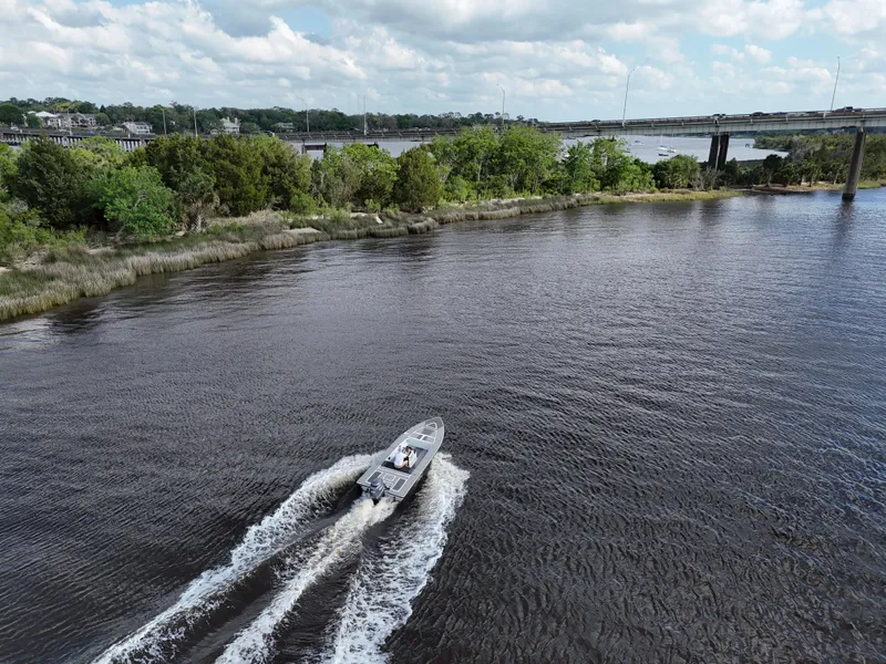 Slide: The Image of Aerial view of 1996 Hewes 18 Redfisher boat cruising on a scenic river. - 12