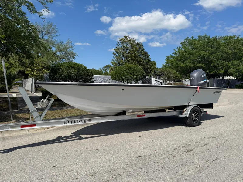 Slide: The Image of 1996 Hewes 18 Redfisher boat on trailer under clear sky. - 14