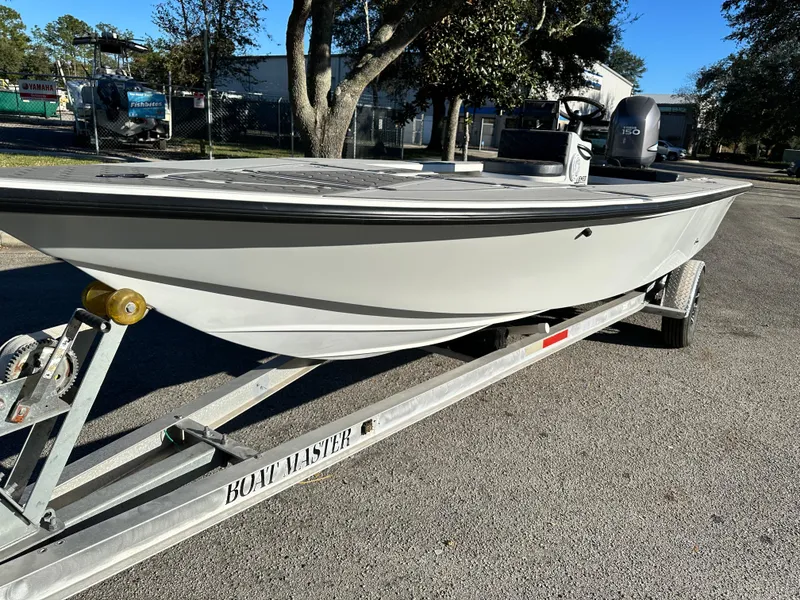 Slide: The Image of 1996 Hewes 18 Redfisher boat on trailer, parked outdoors. - 15
