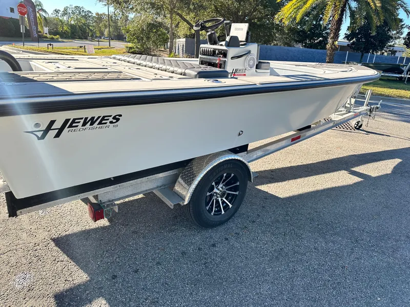 Slide: The Image of 1996 Hewes 18 Redfisher boat on trailer, parked outdoors under sunlight. - 16