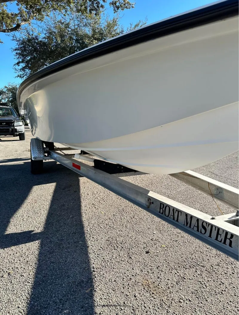 Slide: The Image of 1996 Hewes 18 Redfisher boat on a Boat Master trailer, parked outdoors. - 19