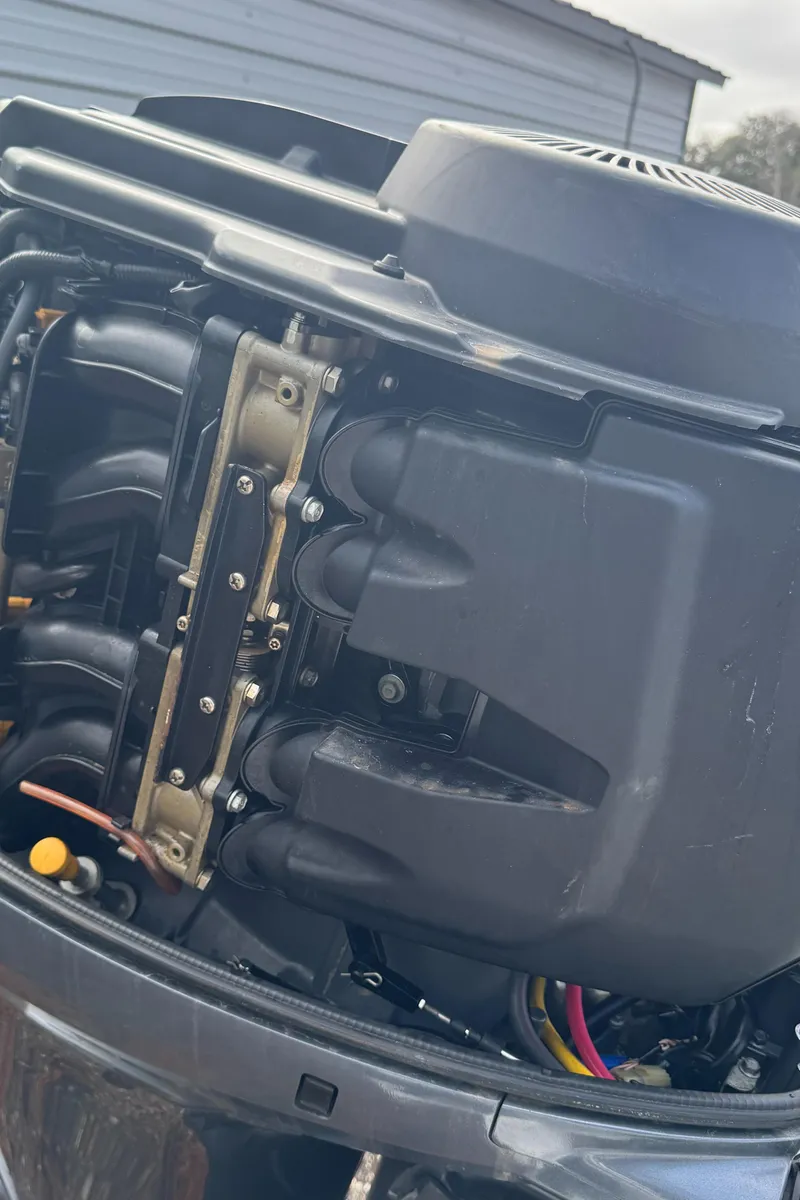 Slide: The Image of Close-up of a 1996 Hewes 18 Redfisher boat engine, showcasing mechanical components. - 25