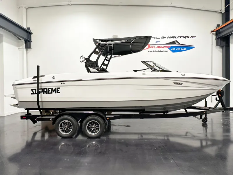 The Image of 2025 Supreme S240 boat on trailer in showroom, side view. - 1