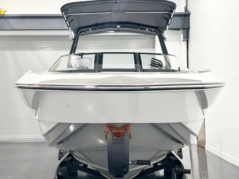 Slide: The Image of 2025 Supreme S240 boat in showroom, front view, sleek design, black canopy. - 3