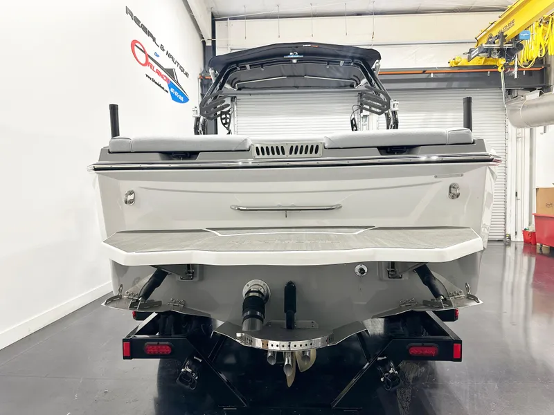 Slide: The Image of Rear view of 2025 Supreme S240 boat in a showroom setting. - 5