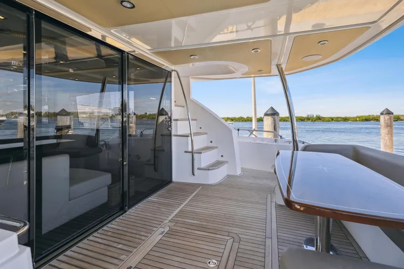 Slide: The Image of 2014 Sunseeker Manhattan 73 yacht deck with elegant seating and scenic water view. - 11
