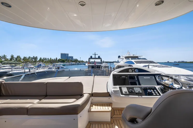 Slide: The Image of Luxurious 2014 Sunseeker Manhattan 73 yacht interior with helm and seating, docked at marina. - 3