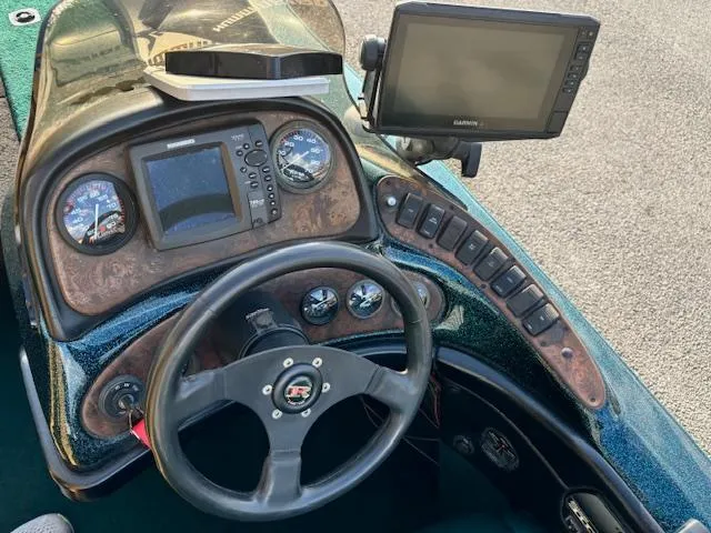 Slide: The Image of Dashboard of a 1998 Ranger 518DVX boat with steering wheel and navigation equipment. - 10