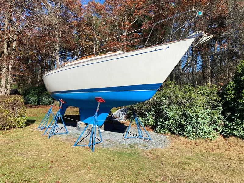 Slide: The Image of 1982 Morgan 32 sailboat on stands, surrounded by autumn foliage. - 10