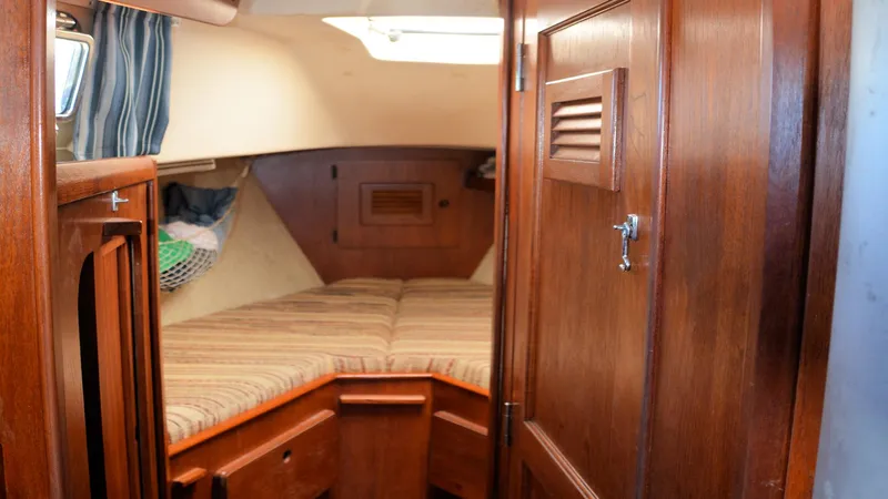 Slide: The Image of 1982 Morgan 32 sailboat cabin interior with wooden finish and cozy sleeping area. - 12