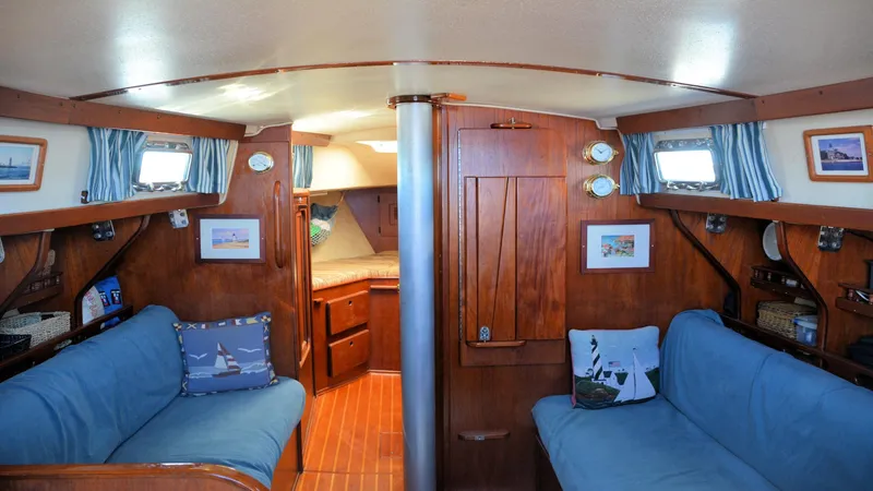 Slide: The Image of 1982 Morgan 32 yacht interior with wooden finish, blue cushions, and nautical decor. - 15