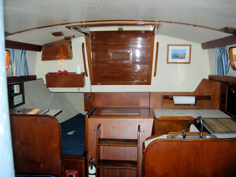 Slide: The Image of 1982 Morgan 32 yacht interior with wooden cabinetry and cozy seating area. - 16