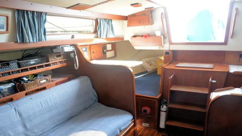 Slide: The Image of 1982 Morgan 32 yacht interior with cozy seating, wooden cabinetry, and nautical decor. - 17