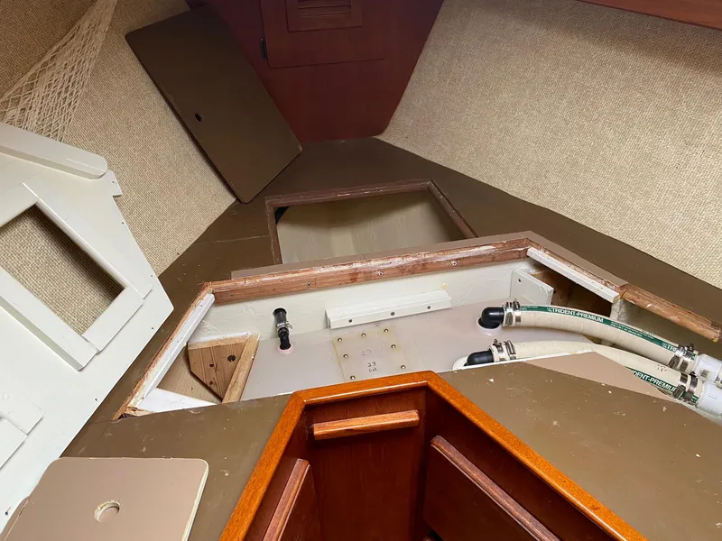 Slide: The Image of Interior of a 1982 Morgan 32 sailboat showing storage compartments and plumbing. - 18