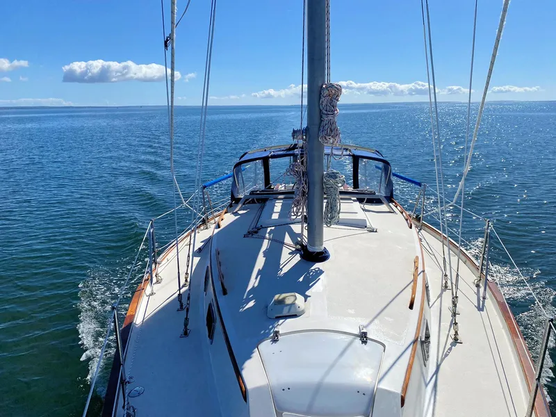 Slide: The Image of Sailing on a 1982 Morgan 32 yacht in calm blue waters under a clear sky. - 2