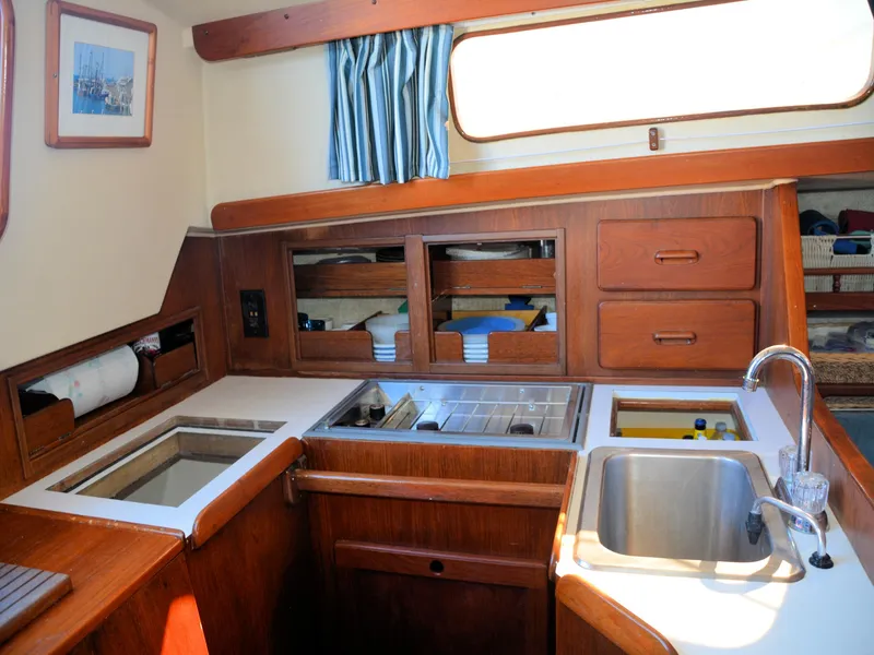 Slide: The Image of 1982 Morgan 32 yacht interior with wooden cabinetry, sink, and storage compartments. - 25
