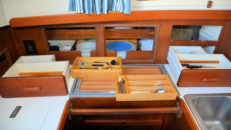 Slide: The Image of 1982 Morgan 32 yacht kitchen with wooden cabinets, utensils, and sink. - 27
