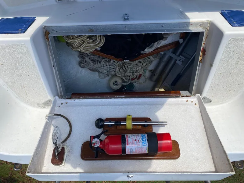 Slide: The Image of Storage compartment on a 1982 Morgan 32 sailboat with fire extinguisher and ropes. - 32