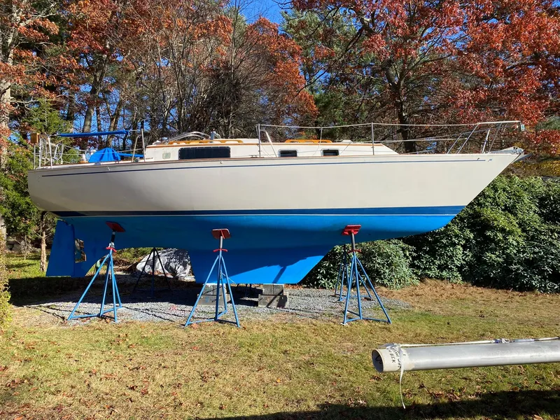 Slide: The Image of 1982 Morgan 32 sailboat on stands, surrounded by autumn trees and grass. - 9