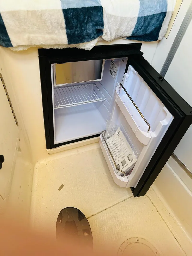 Slide: The Image of 2002 Grady-White Express 265 boat interior with open mini fridge. - 14