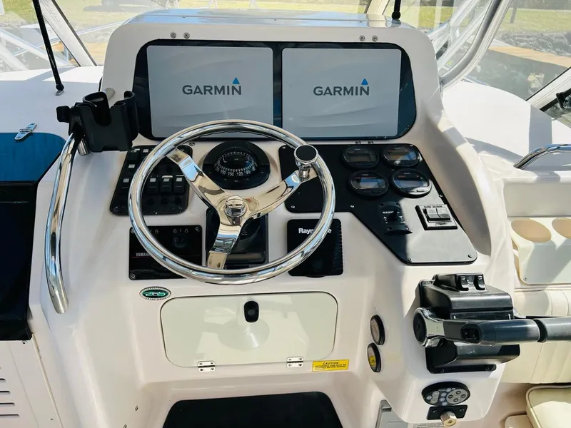 Slide: The Image of 2002 Grady-White Express 265 helm with Garmin navigation displays and steering wheel. - 19