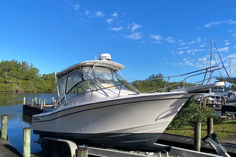 Slide: The Image of 2002 Grady-White Express 265 boat on trailer by a scenic waterfront. - 2