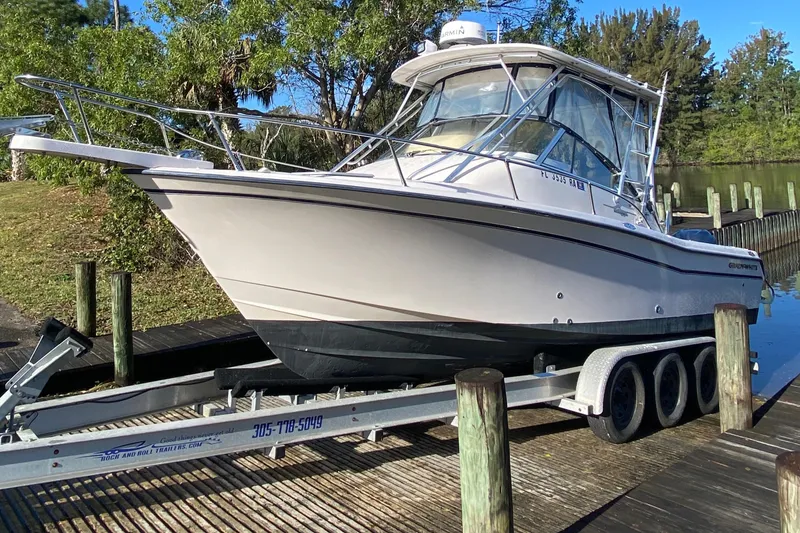 Slide: The Image of 2002 Grady-White Express 265 boat on trailer by dock, surrounded by trees. - 3