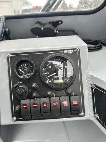 Slide: The Image of Dashboard of a 2021 Hewescraft Sportsman 180 SM boat with gauges and switches. - 10