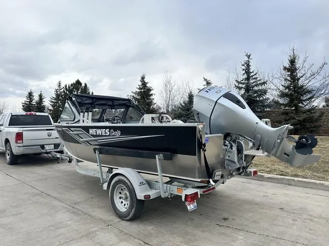 Slide: The Image of 2021 Hewescraft Sportsman 180 SM boat on trailer, parked near trees. - 4